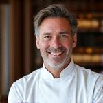 Portrait souriant d'Antoine Dubois, chef passionné de cuisine médiévale