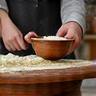Mains d'un participant préparant une pâte dans un bol en cuivre